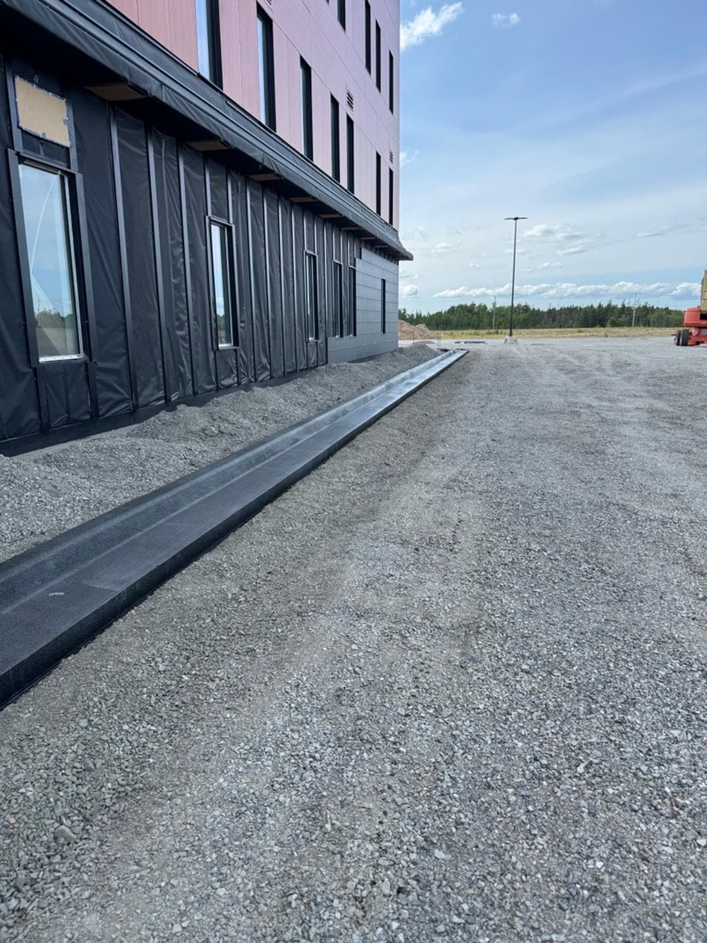 Finished dark ΔC curb along the Mi'kma'ki Place building